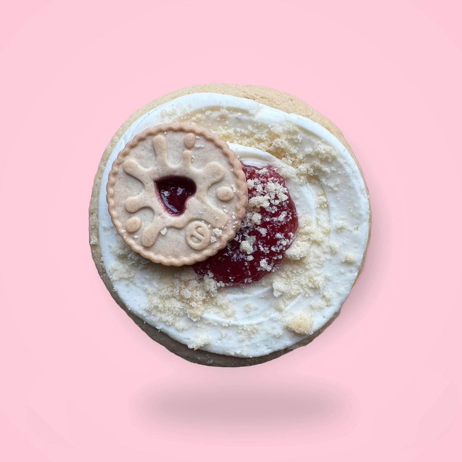 a sugar cookie with a jammy dodger cookie on buttercream and jam