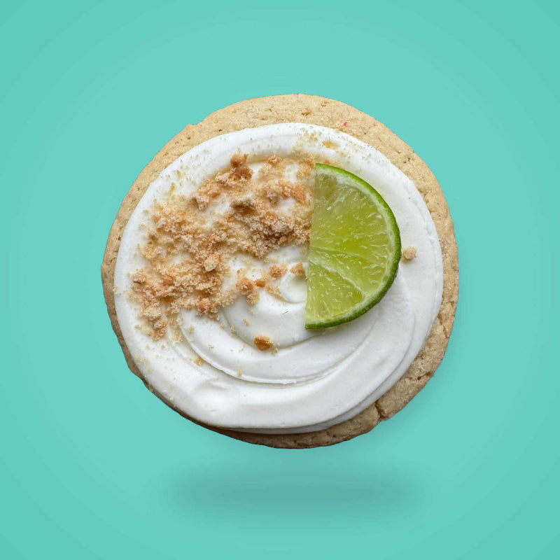 A key lime pie sugar cookie on a turquoise background